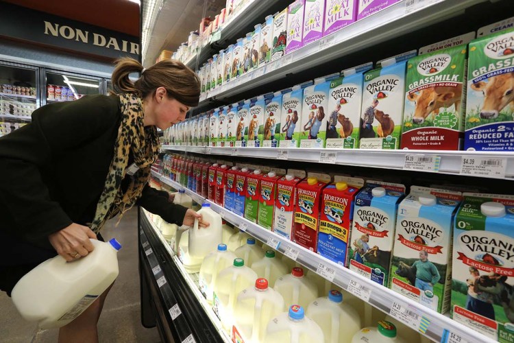 Grocery and dairy assistant Reyna DeLoge stocks dairy products that only use milk from pasture-raised cows, at Vitamin Cottage Natural Grocers, in Denver. As Americans continue turning away from milk, an industry group is pushing back at its critics with a "Get Real" social media campaign. The Associated Press
