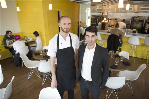 Co-owner Cristian Mora, right, and Chef Brian Oliveira at Girard Brasserie and Bruncherie, where  servers earn about $13 an hour. They also get sick time, vacation days and health insurance. The Associated Press