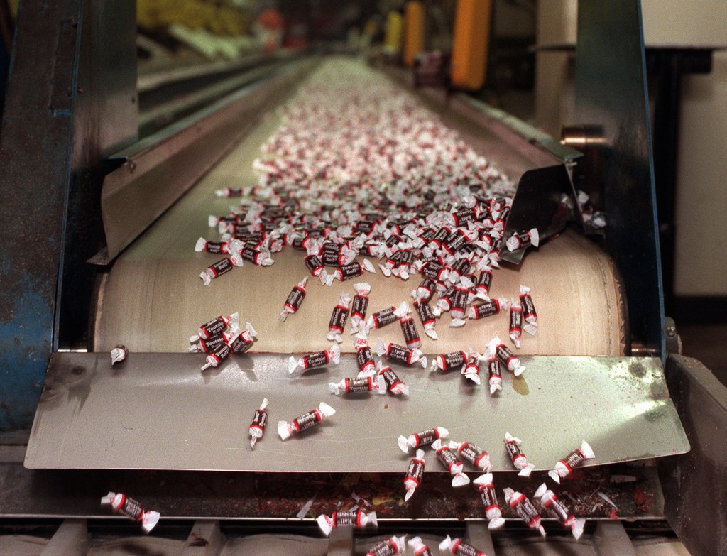 Tootsie Roll candies make their way down a conveyor belt at a plant in Chicago. The Associated Press