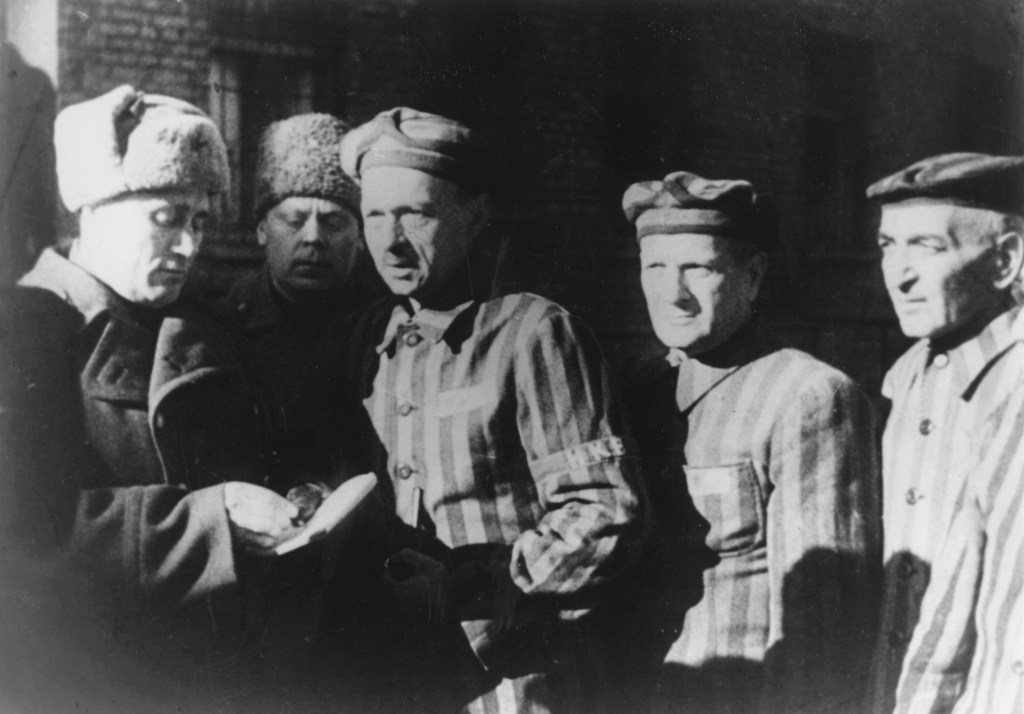 Three Auschwitz prisoners talk with Soviet soldiers after the Nazi concentration camp in Poland, was liberated by the Russians in January 1945. The Associated Press