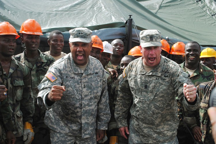 Maj. Gen. Darryl Williams, left, head of U.S. troops in Liberia, and Sgt. Maj.  Jeffery T. Stitzel cheer on Liberian soldiers at an Ebola treatment center, under construction in Tubmanburg last fall. Reuters