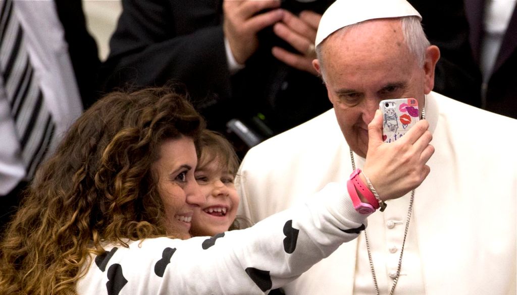 A woman and a child take a selfie photo with Pope Francis  during his weekly general audience in the Paul VI hall at the Vatican, Wednesday. The Associated Press