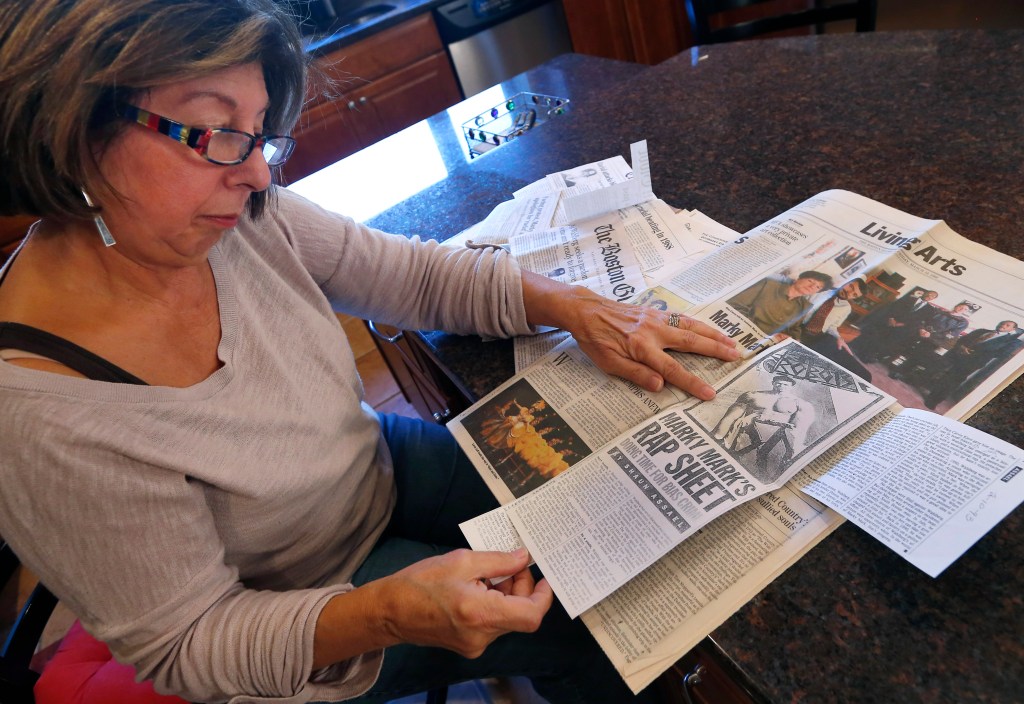 In this Dec. 15, 2014, photo, Mary Belmonte reviews newspaper clippings she'd collected about Mark Wahlberg at her home in Westwood, Mass. Belmonte, a retired teacher, spoke about a 1986 incident where she was escorting 9- and 10-year-old students to Savin Hill beach when Wahlberg and his friends attacked them with rocks and racial epithets. The Associated Press