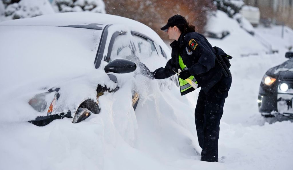 Norwich, Conn., police officer Heather Buonanni tickets an illegally parked car. The storm dumped nearly 2-feet of snow in the region. The Associated Press / The Day, Sean D. Elliot