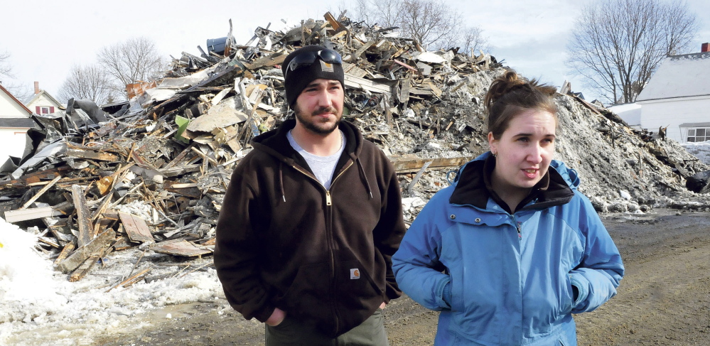 Chad Dambois and Megan Hale speak on Tuesday in front of a pile of rubble, all that remains of the apartment building where they lived until a fire destroyed it Monday. Hale said she lost everything, including irreplaceable personal belongings.