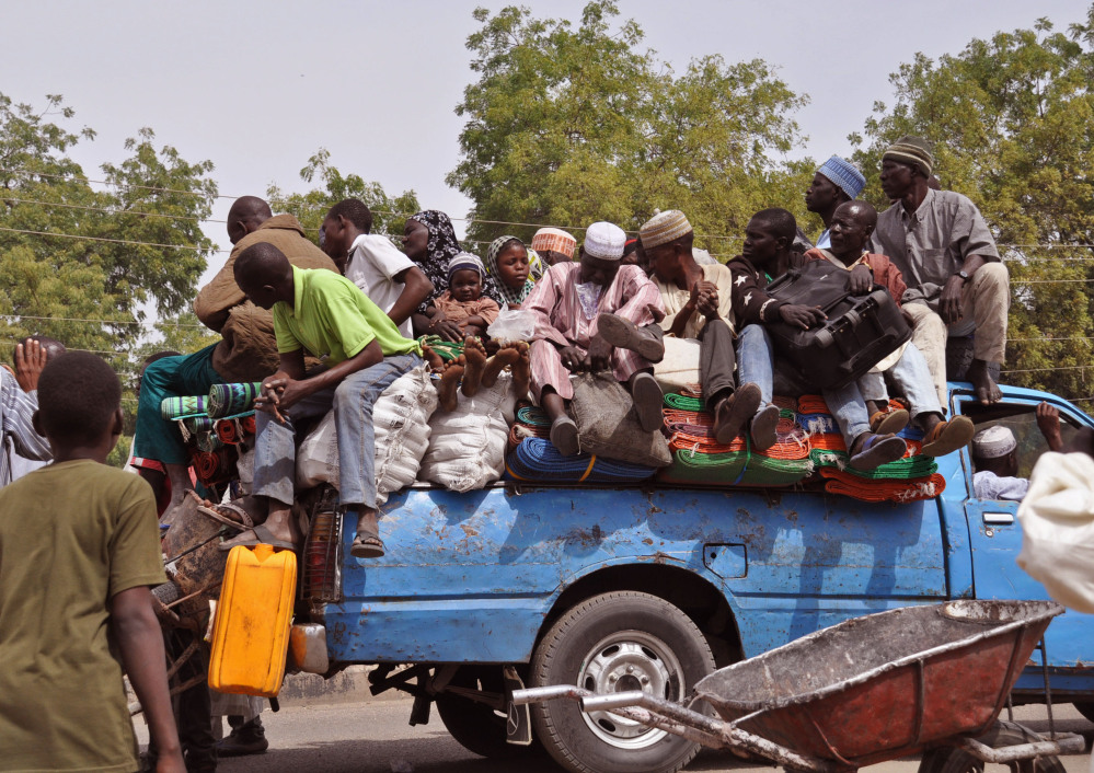 Villagers wait on a small truck as they and others flee recent violence near Maiduguri, Nigeria. The Associated Press