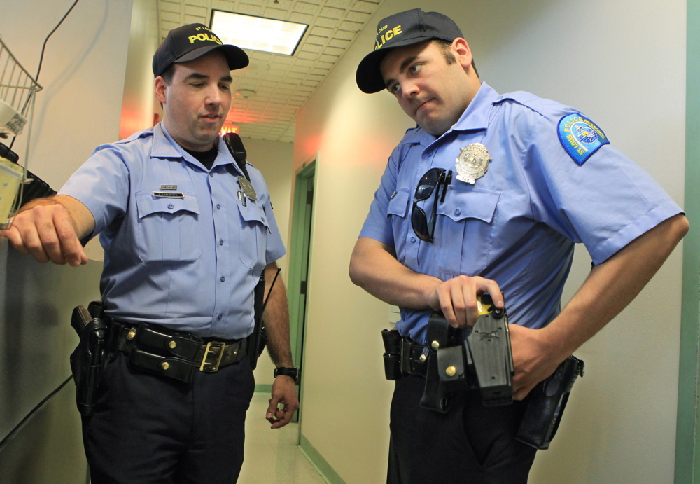 A St. Louis patrolman, right, gets training on handling a Taser. Police need to be trained to think differently in potentially violent situations, say officials looking to reduce deadly force incidents. “Tactical retreat” is a method advocated by some.