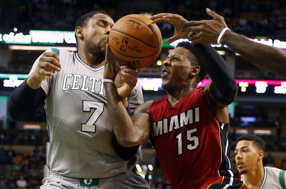 Miami Heat’s Mario Chalmers, 15, tries to hold on to the ball while getting by Boston Celtics’ Jared Sullinger in the first half Sunday in Boston.