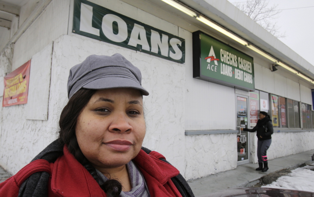 A customer stands outside a payday loan business in Cleveland where she initially borrowed $500 but was forced to keep borrowing to pay back the initial loan. A federal agency is stepping up enforcement to prevent cycles of high-rate debt.