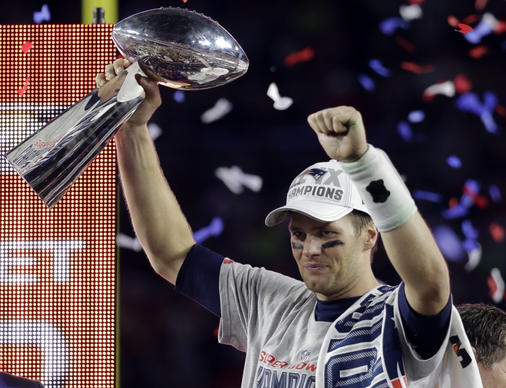 Patriots quarterback Tom Brady hoists the Lombardi Trophy after being named the Super Bowl MVP.