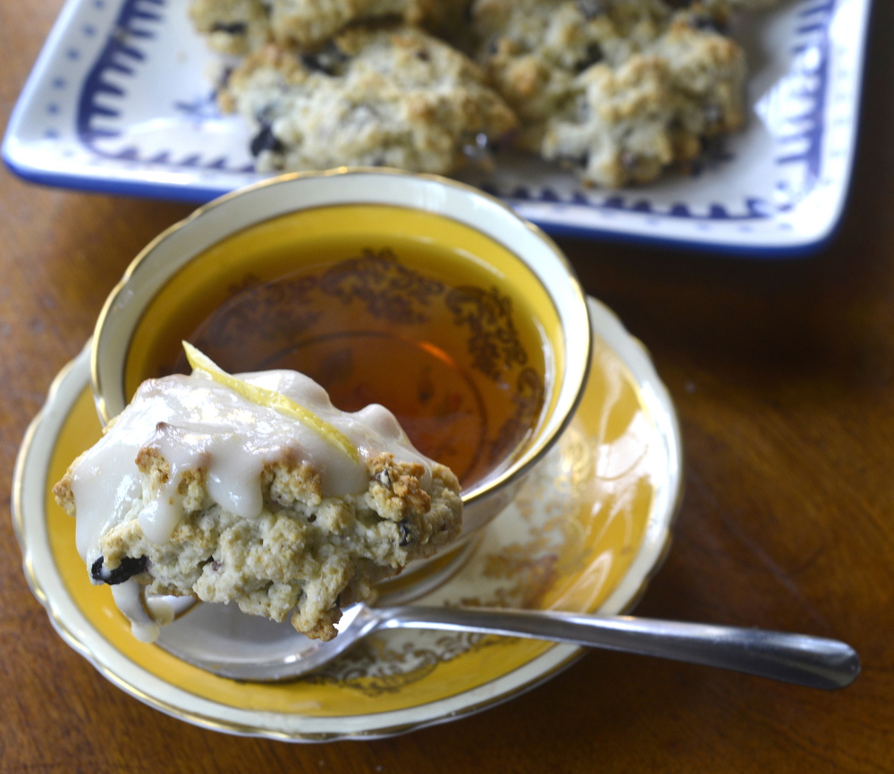 Vegan lemon curd atop a blueberry scone, served with a hot cup of tea