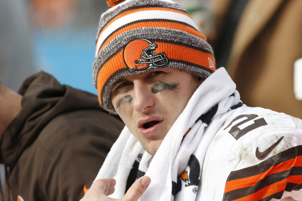 In this Sunday, Dec. 21, 2014, file photo, Cleveland Browns quarterback Johnny Manziel (2) sits on the bench during the second half of an NFL football game against the Carolina Panthers in Charlotte, N.C.