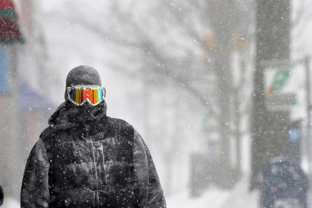 Guy Cournoyer of Northampton adds some color to an otherwise whiteout day in downtown Northampton, Mass., on Monday. Cournoyer says the combination of ski goggles and a full head-covering balaclava leaves no exposed skin.