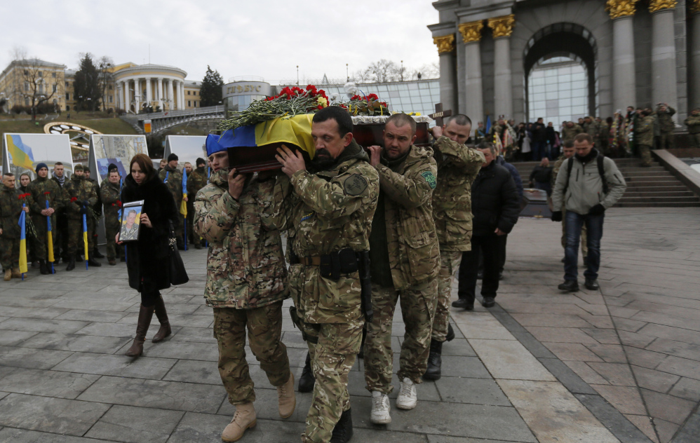 Ukrainian soldiers carry a coffin in Kiev, Ukraine, bearing the body of a serviceman who was killed in fighting against Russian-backed separatists. Ukraine officials say five soldiers were killed and 29 wounded in fighting Monday.