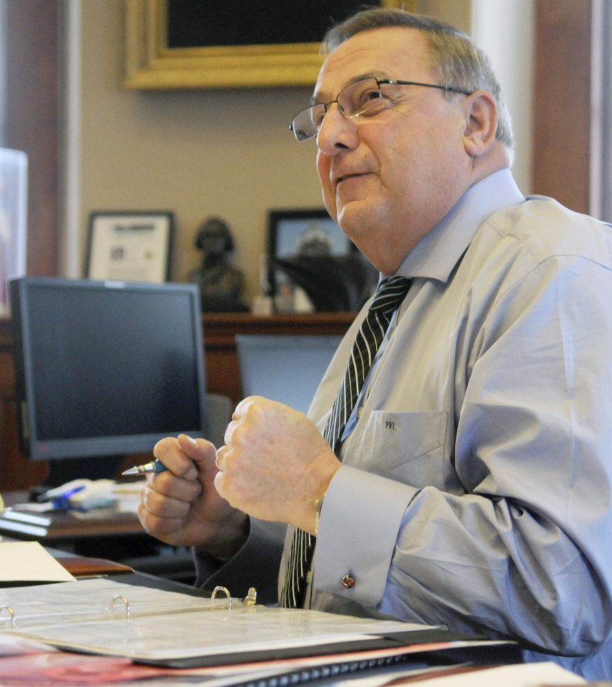 Gov. Paul LePage discusses a point he intends to make in Tuesday’s State of the State address while drafting the speech Monday in his Augusta office.