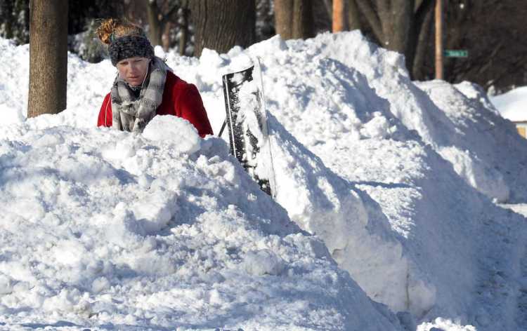 Lauren Rosengarden of Mount Prospect, Ill. digs out her driveway on Monday the day after a significant snowfall. The Associated Press