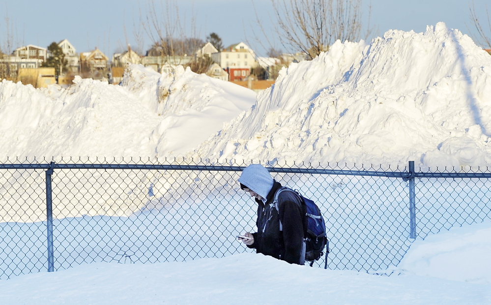 Amid piles of snow, Andrew Bove trudges home from work at the Preble Street Resource Center. It could be worse: Eastport got 76 inches in a week.