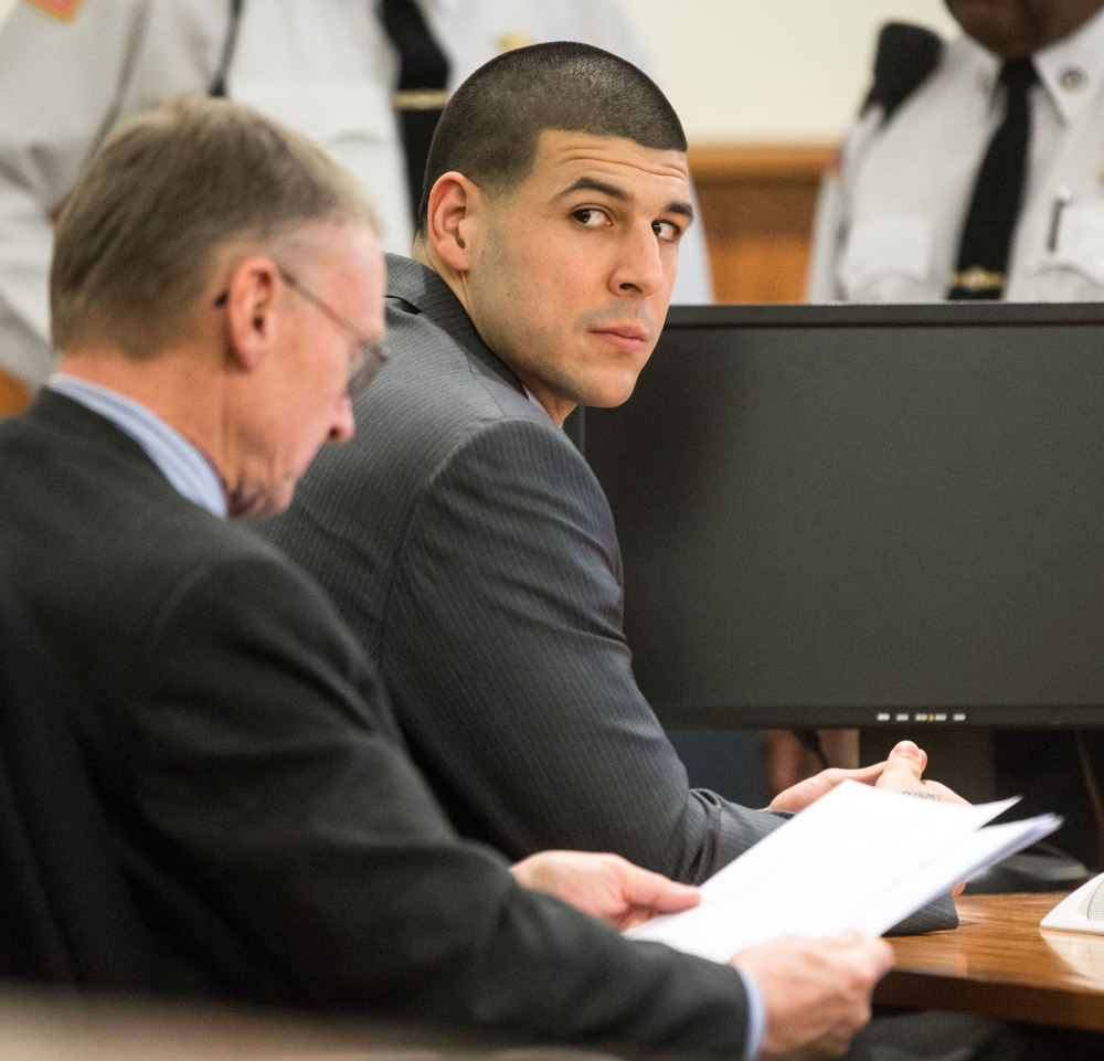 Former New England Patriots player Aaron Hernandez, right, glances towards the Lloyd family during his trial at Bristol County Superior Court in Fall River, Mass.