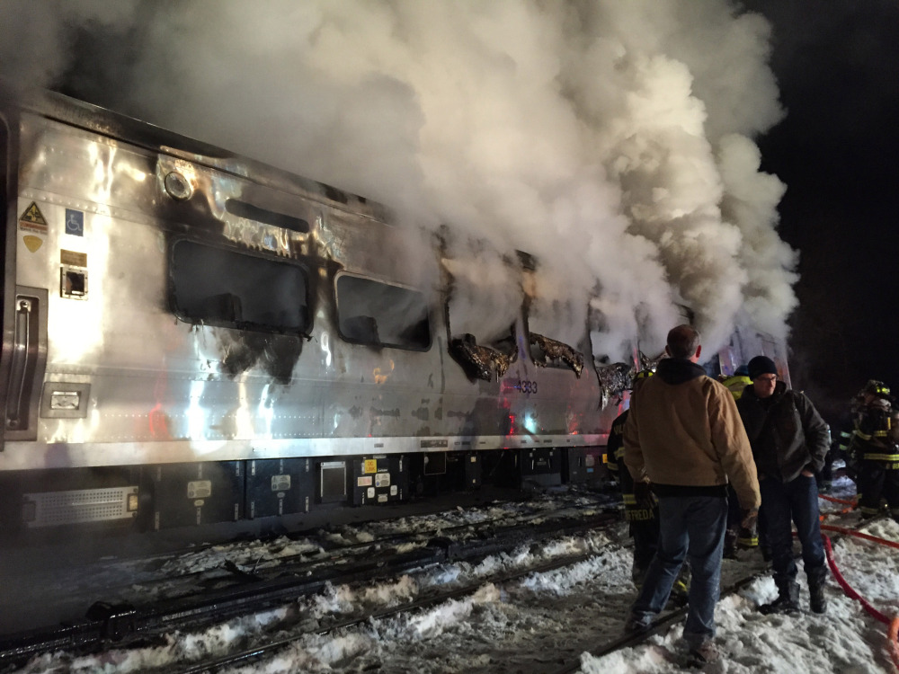 The Metro-North Railroad passenger train smolders after hitting a sport utility vehicle Tuesday evening in Valhalla, N.Y.