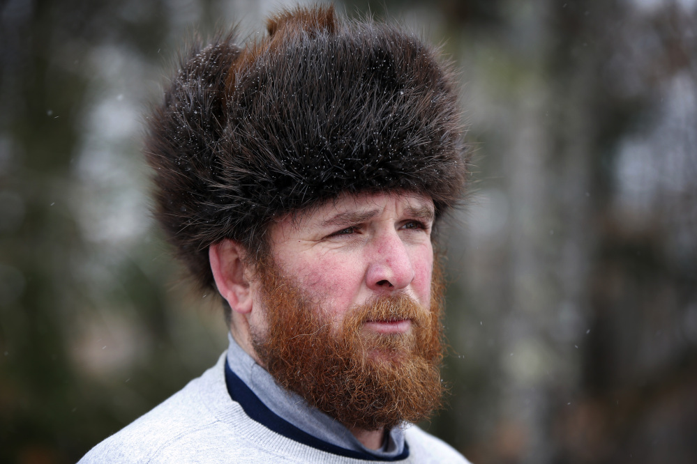 Trapper Brian Cogill wears a fur hat he had made from a beaver he trapped.