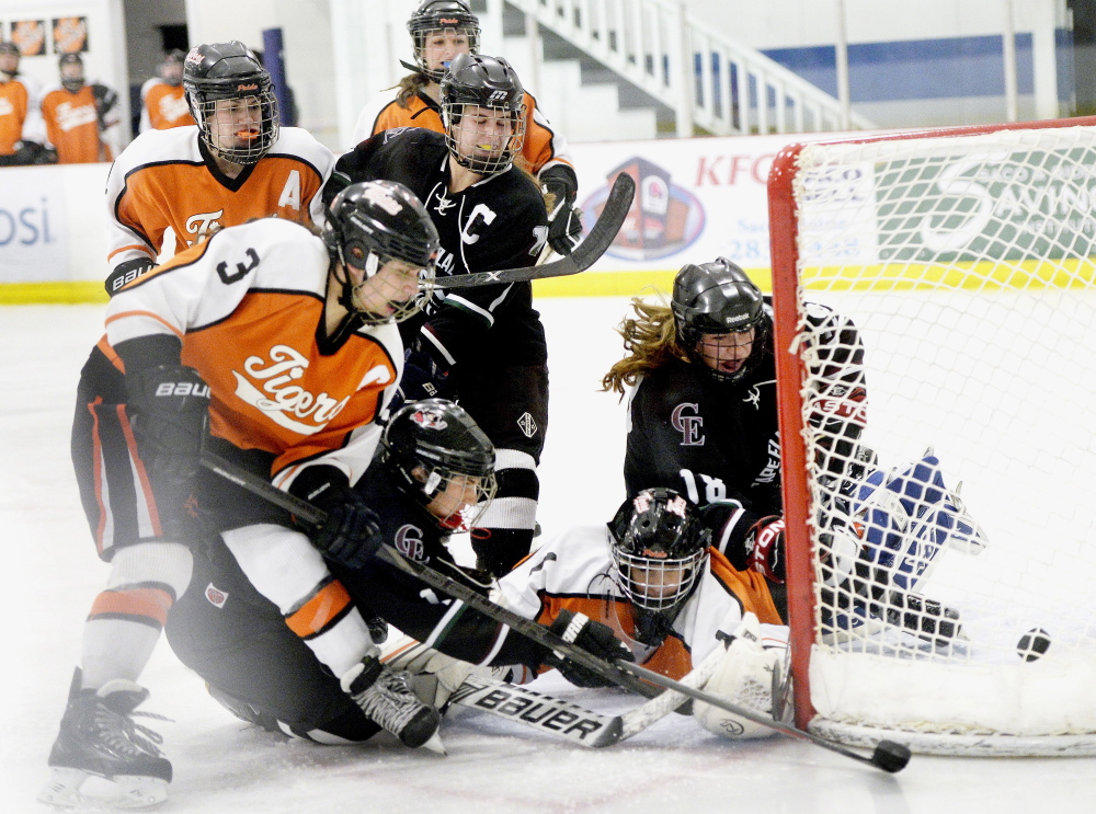 Biddeford goalie Rebekah Guay scrambles to control the puck, but is beaten to it by Kathryn Clark, lower left, who scores late in the third period for Cape Elizabeth/Waynflete/South Portland in a 3-2 win Wednesday night at Biddeford.