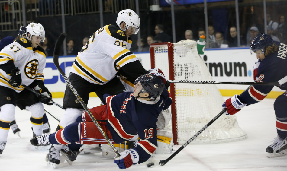 Bruins defenseman Kevan Miller levels New York Rangers right wing Jesper Fast as Rangers left wing Carl Hagelin maneuvers the puck in the crease in the second period of Wednesday night’s game at Madison Square Garden in New York.