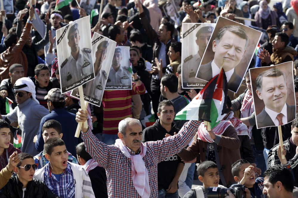 Jordanians show their support for the government’s strikes against the Islamic State during a rally Thursday in Amman. Two posters of Jordan’s King Abdullah II are held at right and the others show the murdered Jordanian pilot Lt. Muath al-Kaseasbeh.