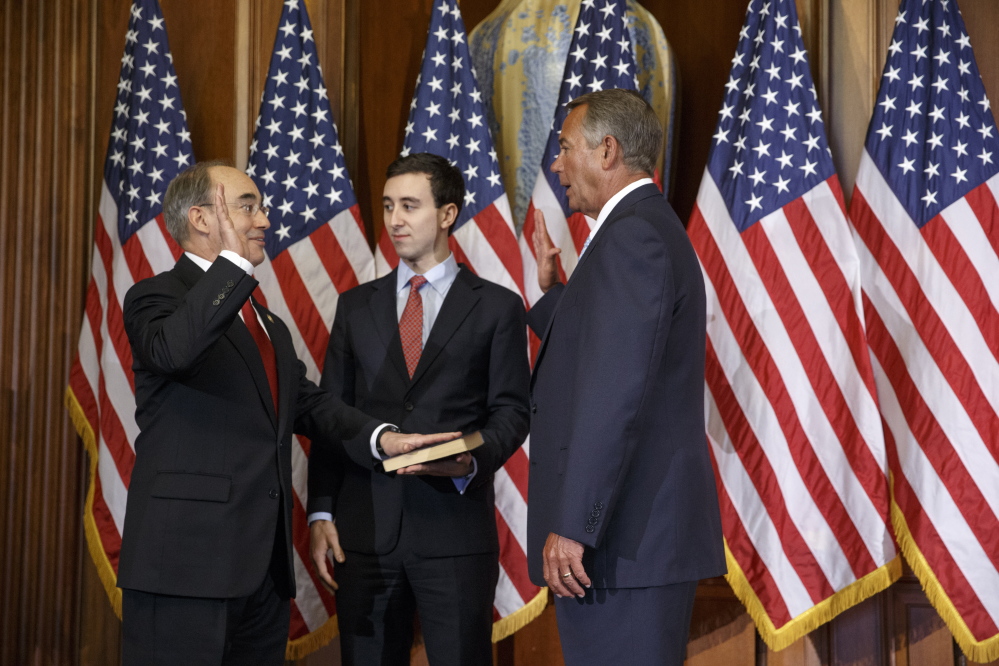 2nd District U.S. Rep. Bruce Poliquin, left, with his son Sam, center, is sworn in by House Speaker John Boehner on Jan. 6. Poliquin bucked his own party by voting against the most recent Republican proposal to repeal Obamacare.