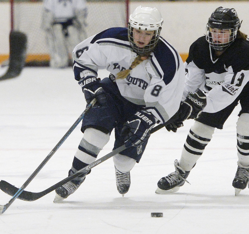 Jenny Holmquist, left, of Yarmouth/Freeport/Gray-New Gloucester, skates forward with Jessica Boulet of Saint Dominic in a girls’ hockey quarterfinal game played Feb. 5. Yarmouth/Freeport/Gray-New Gloucester won the game, 8-1.