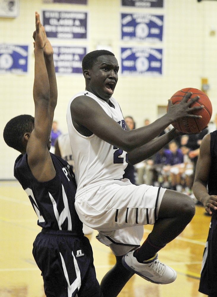 Deering’s Moses Oreste splits a pair of Portland defenders on his way to the hoop Thursday night. The Rams end the regular season with a 12-6 record, while Portland enters the playoffs with a 16-2 record.