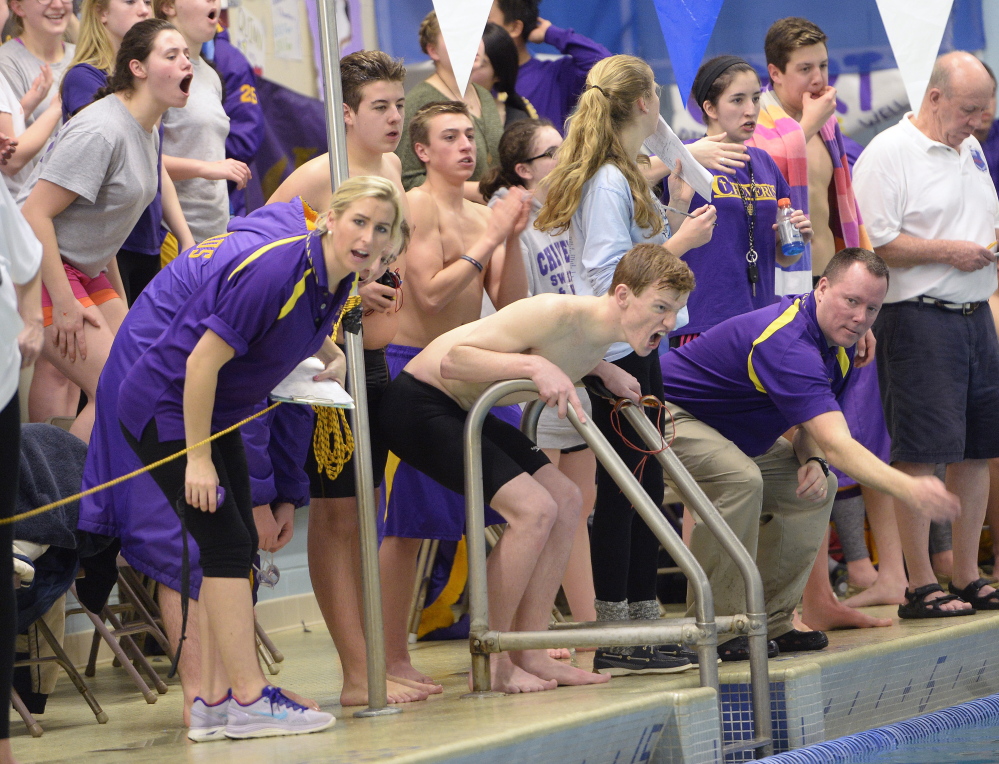 Cheverus Coach Kevin Haley, right, and his swimmers cheer on their teammates at the boys’ North Southwesterns in Westbrook on Feb. 6. The Stags earned their third consecutive league championship with 335 points, far ahead of runner-up Cape Elizabeth (221).