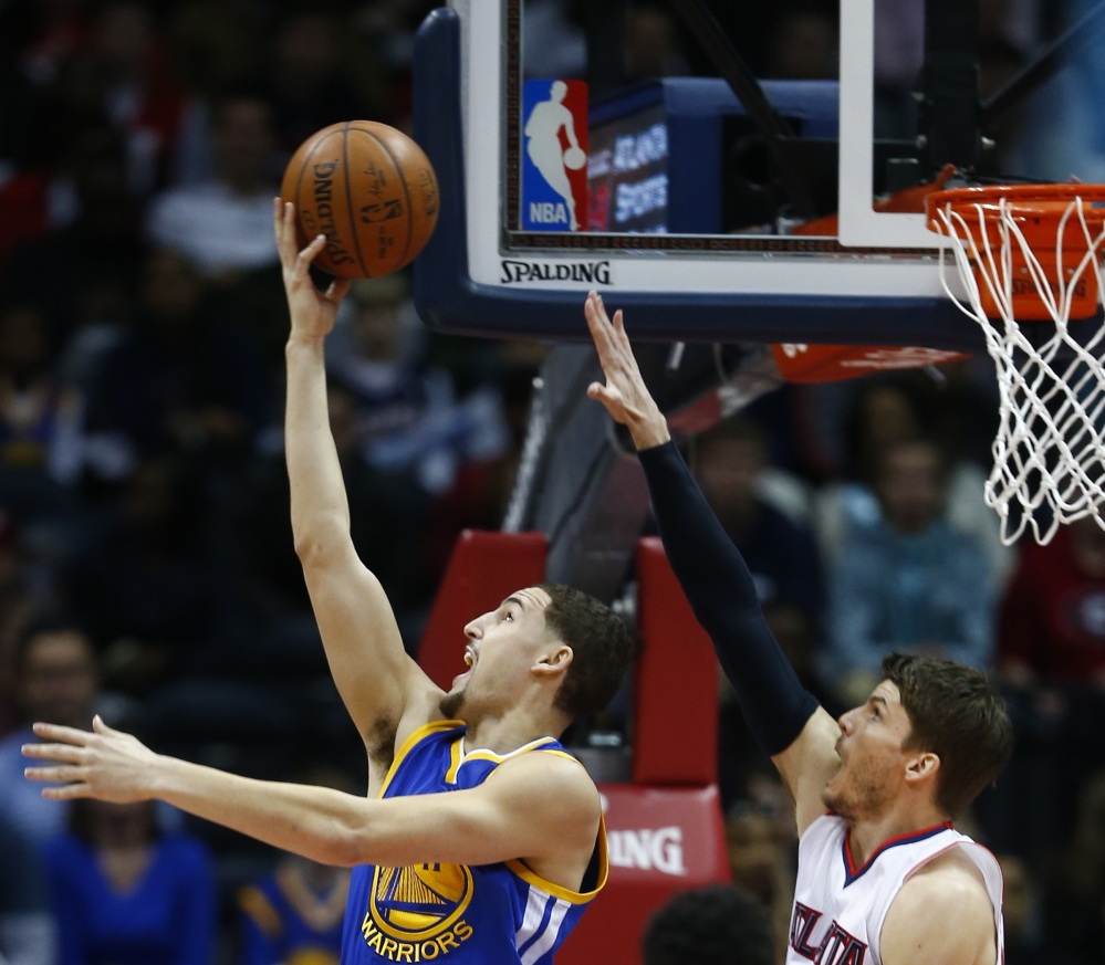Golden State Warriors guard Klay Thompson goes up for a shot as Atlanta Hawks guard Kyle Korver defends during the Hawks’ 124-116 win Friday in Atlanta.