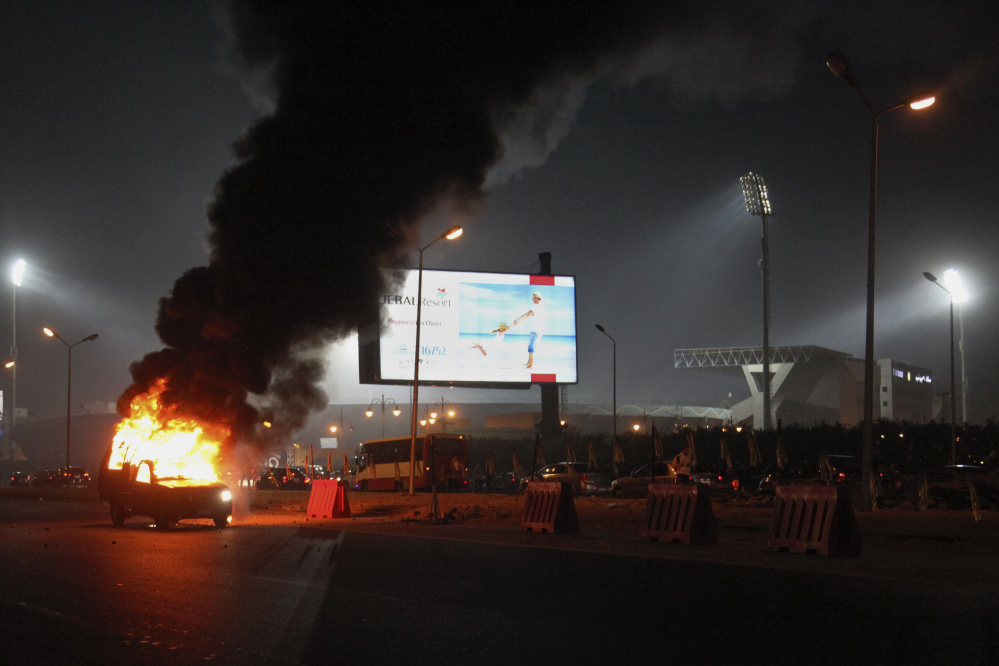 A pickup truck bursts into flames as a riot breaks out outside of a soccer match between Egyptian Premier League clubs Zamalek and ENPPI at Air Defense Stadium in a suburb east of Cairo, Egypt. The riot broke out Sunday night outside of the major soccer game, with a stampede and fighting between police and fans killing at least 22 people, authorities said.