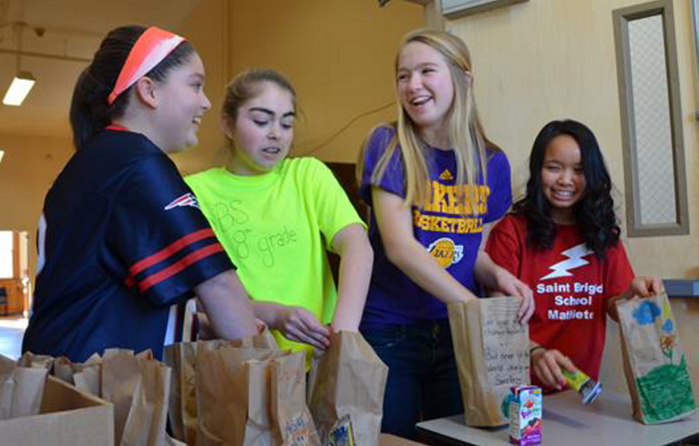 Students at St. Brigid Catholic School in Portland prepare bags of healthy snacks collected by eighth-graders to distribute to children in community programs.