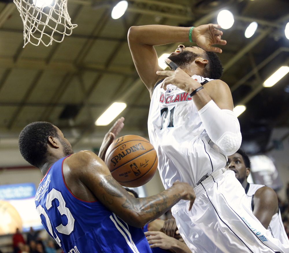 Christian Watford of the Red Claws is fouled by Victor Rudd of the 87ers while driving to the basket in the second quarter Sunday at the Portland Expo.