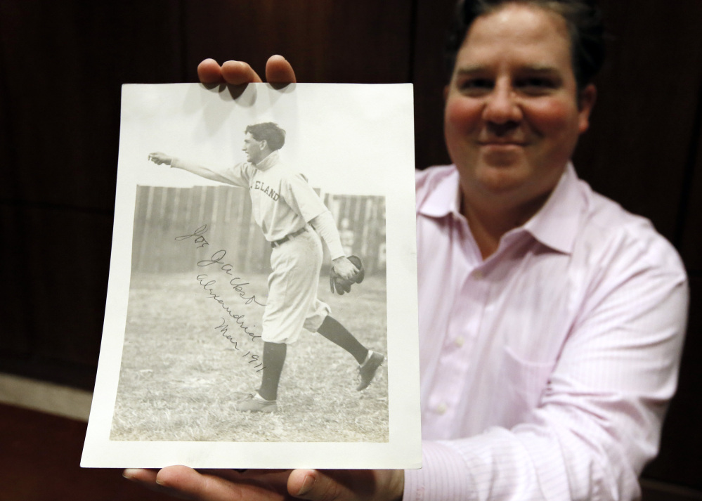Chris Ivy, director of sports auctions at Heritage Auctions in Dallas, holds a 1911 autographed photo of Cleveland ballplayer Joe Jackson. It may be the only autographed photo of “Shoeless Joe.”