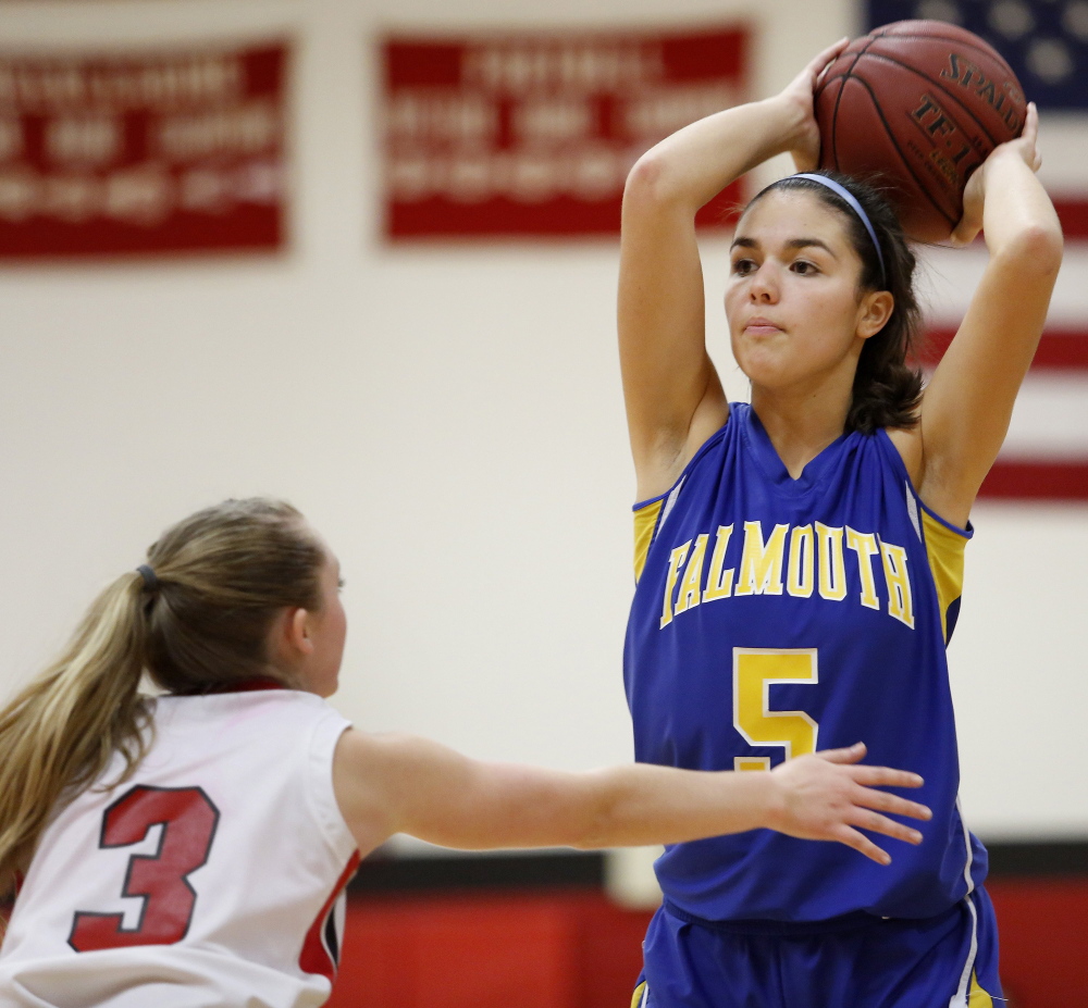 WELLS, ME - DECEMBER 11: Falmouth’s Dayna Vasconcelos looks for a lane to pass the ball over Wells  defender Hannah Moody during a girls basketball game, Thursday, December 11, 2014.