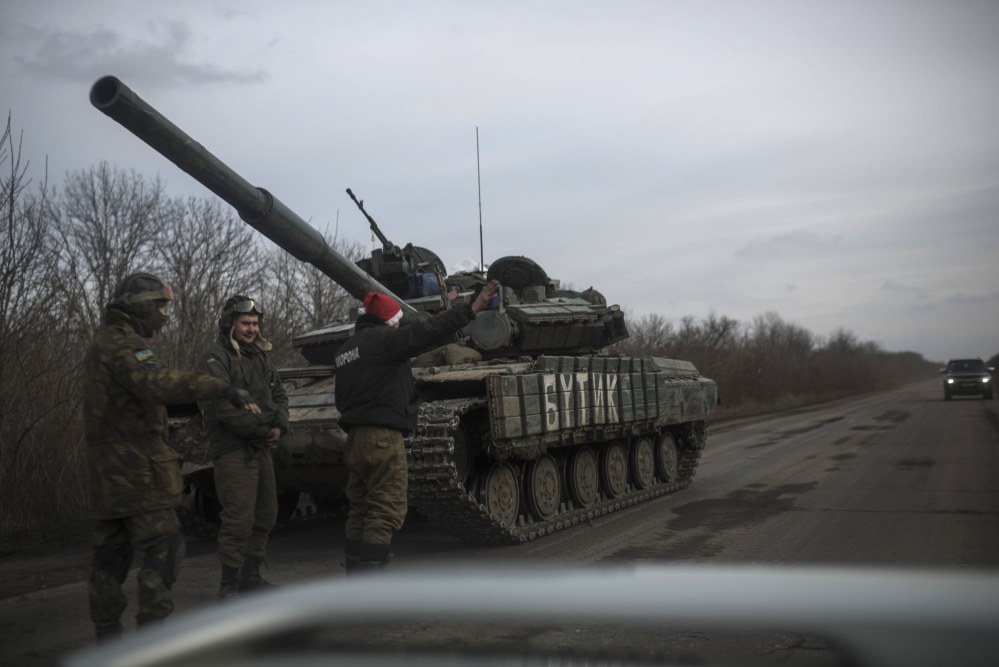 Ukrainian soldiers ask for a lift as that stand near their military vehicle near Debaltseve, eastern Ukraine, Sunday.
