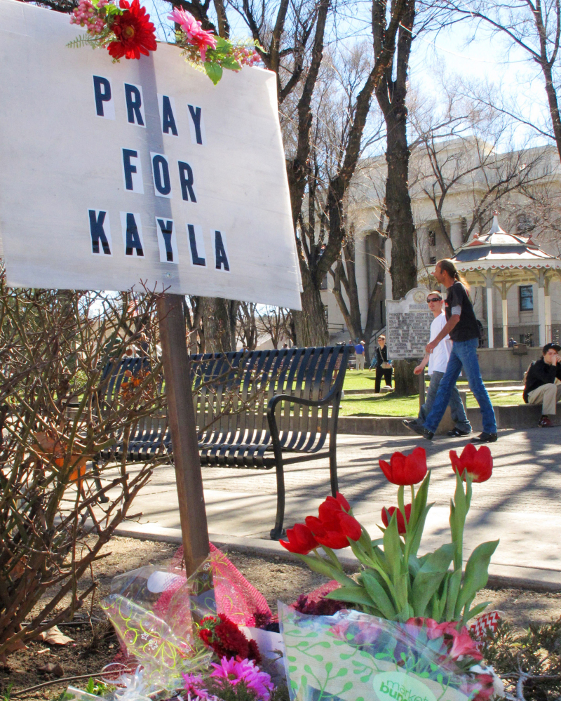 A memorial, at left, honoring American hostage Kayla Mueller, above, is growing at a corner of the courthouse plaza in Prescott, Ariz. Mueller was helping refugees in war-torn Syria when she was captured in August 2013.