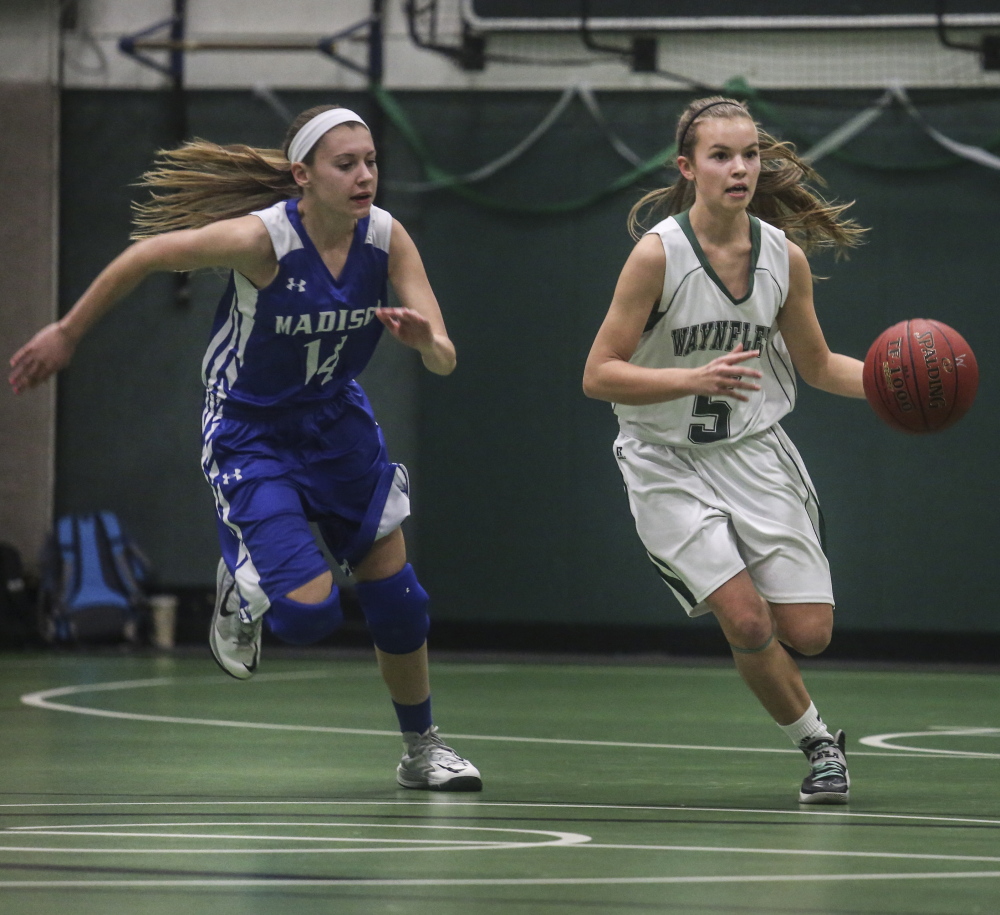 Izzy Burdick of Waynflete looks for room to drive Tuesday night against Sydney LeBlanc of Madison during Madison’s 48-41 victory in a Western Class C prelim at Waynflete. Madison ended the game on a 14-4 run.