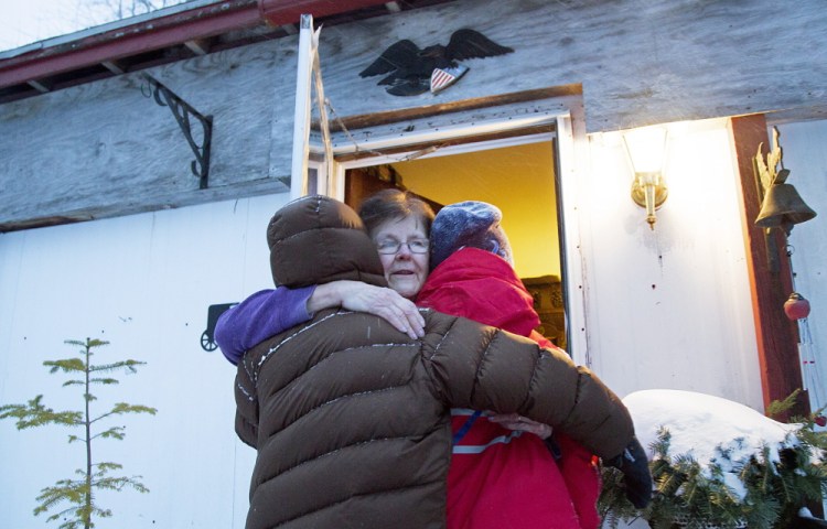 Boy Scout patrol leaders Harrison Holmes, 12, left, and Sam Yankee, 11, get a hug from Nancy Taylor after a dozen Scouts cleared 4 feet of snow from around her house. Taylor was worried that she couldn’t get out of the home if she had a second heart attack.
