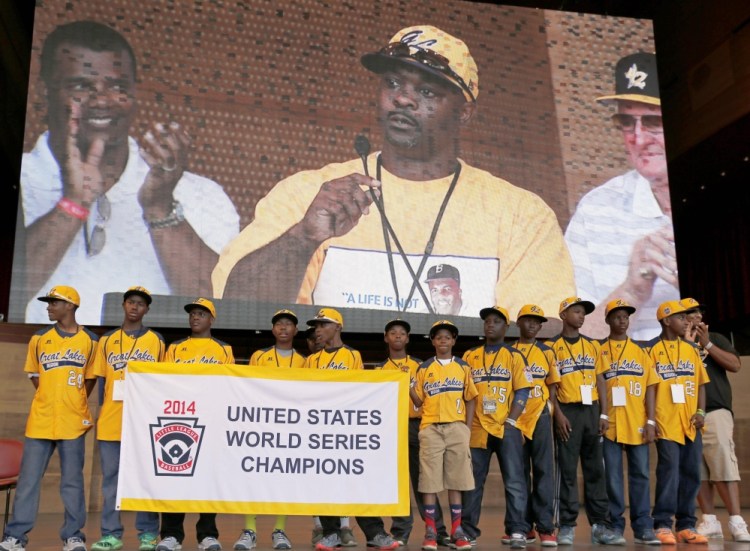 In this Aug. 27, 2014 file photo, members of the Jackie Robinson West All Stars Little League baseball team participate in a rally and listen to manager Darold Butler on the big screen as they celebrate the team’s U.S. Little League Championship in Chicago.