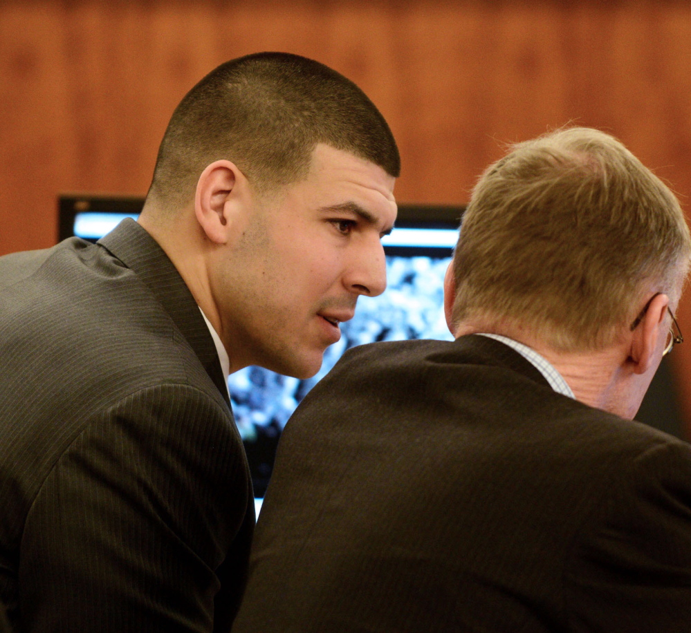 Former New England Patriots player Aaron Hernandez, left, talks with his attorney Charles Rankin during the trial at Bristol Superior Court on Wednesday in Fall River, Mass.