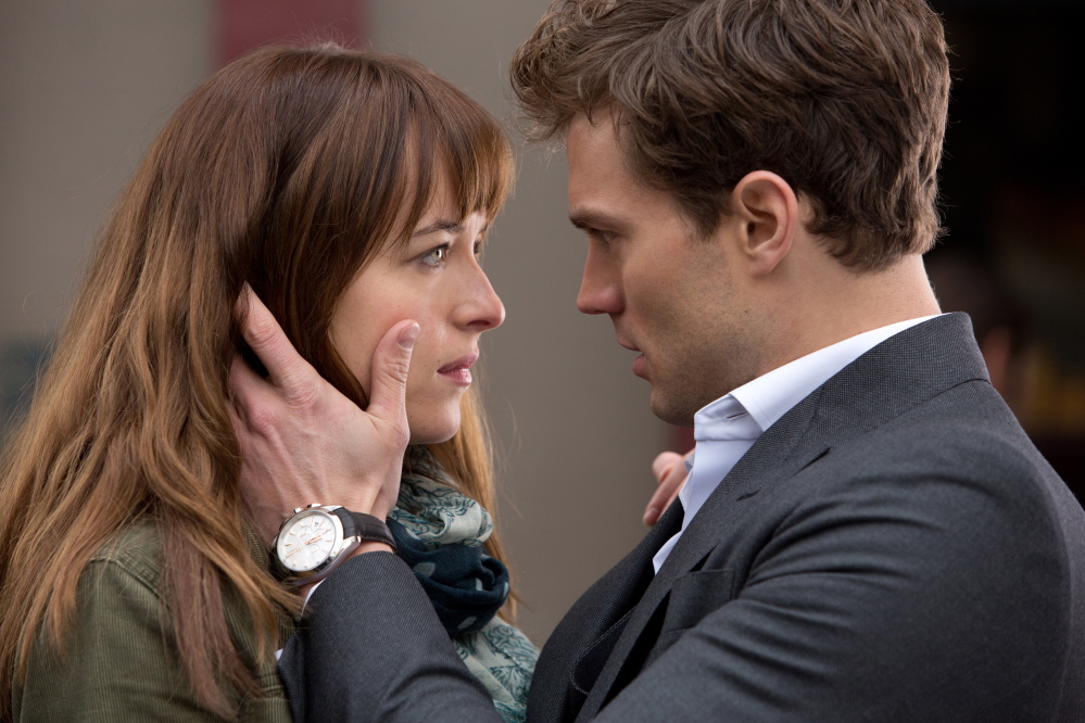Dakota Johnson, left, and Jamie Dornan appear in a scene from “Fifty Shades of Grey.”