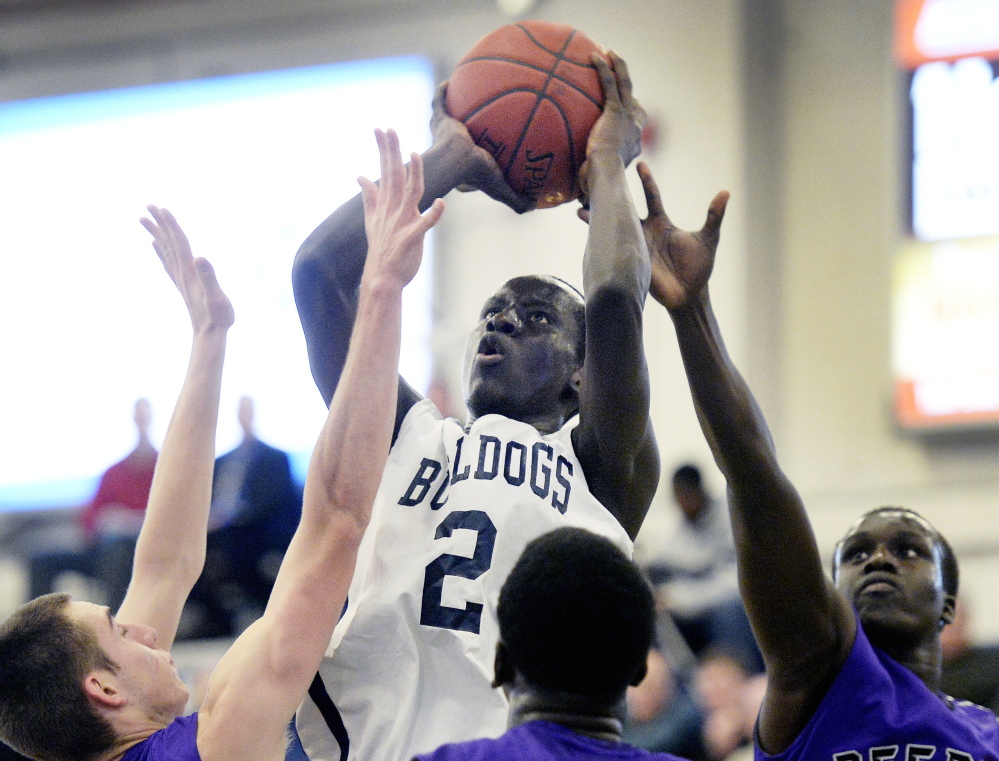 Portland’s Stephen Alex shoots over a crowd of Deering defenders during their game on Jan. 15. Alex is averaging 17 points for the defending Class A state champions.