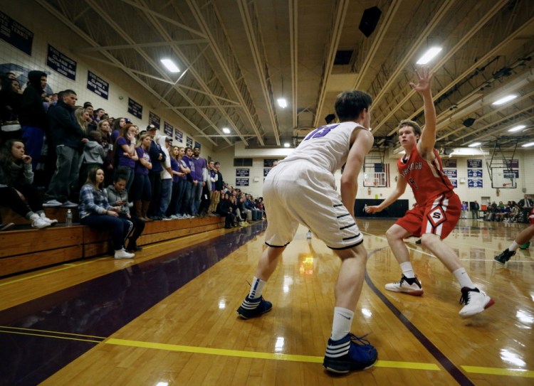 Ian Corey of Scarborough High defends against Max Chabot of Deering High as he sets up near the 3-point line during a game at Deering. The 3-point arc is 19 feet, 9 inches from the basket. In Yarmouth, Coach Adam Smith says, “All of our starting five have a green light to shoot the 3-pointer.”