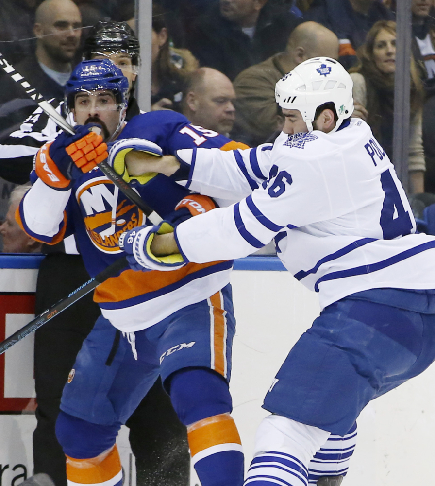 Maple Leafs defenseman Roman Polak, right, holds Islanders right wing Cal Clutterbuck in the first period of Thursday night’s game at Uniondale, N.Y. The Islanders won 3-2 as Toronto fell to 1-12-1 in their last 14 games.