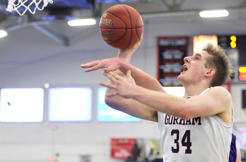 Sam Kilborn of Gorham gets to the basket while avoiding an attempted block from a Deering defender. Kilborn finished with 13 points.