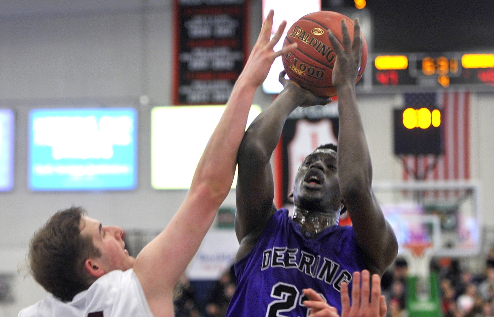 Garang Majok, who scored 10 points for Deering, lifts a shot over Sam Kilborn of Gorham during Deering’s 61-59 victory Friday night in a Western Class A quarterfinal at the Portland Expo. Majok hit two late free throws that helped propel the Rams into a semifinal against Portland.