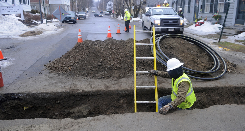 A contractor installs a distribution line last year across Second Street in Hallowell for Summit Natural Gas of Maine. The company has paid more than $100,000 in reimbursements to Kennebec valley customers for missing a hookup deadline.